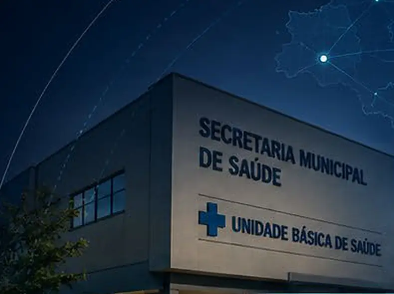 Fachada de uma Unidade Básica de Saúde com a placa Secretaria Municipal de Saúde, à noite